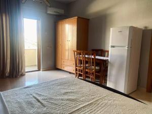 a kitchen with a refrigerator and a table and chairs at Imperial apartments in Ksamil