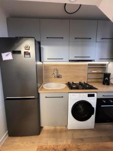 a kitchen with a refrigerator and a washing machine at Best choice flat in Târgu-Mureş