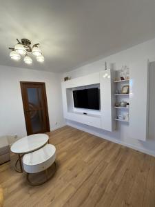 a living room with a table and a tv at Best choice flat in Târgu-Mureş