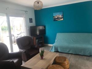 a blue bedroom with a bed and a tv at 760 - Charmante maison aux Hôpitaux a mi-chemin entre Erquy et la station des Sables d'Or in Erquy