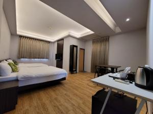 sypialnia z łóżkiem i biurkiem z telewizorem w obiekcie 嘉的家 w mieście Zhuangwei