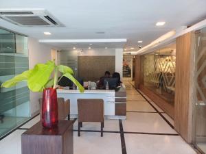 a lobby with a desk with a plant in a vase at Hotel Marina Inn Egmore Chennai in Chennai