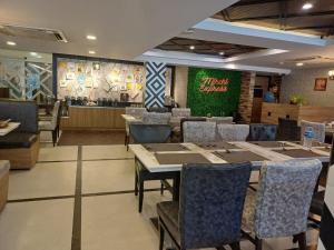 ein Restaurant mit Tischen und Stühlen und eine Bar in der Unterkunft Hotel Marina Inn Egmore Chennai in Chennai