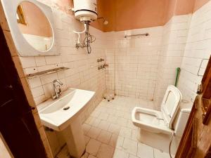 a bathroom with a toilet and a sink and a mirror at The Kanchan Hotel & Restaurant Manali in Manāli