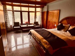 a bedroom with a large bed and a large window at The Kanchan Hotel & Restaurant Manali in Manāli