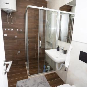 a bathroom with a shower and a toilet and a sink at Apartman ED in Jahorina