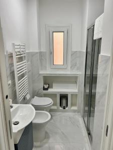 La salle de bains est pourvue de 2 toilettes, d'un lavabo et d'un miroir. dans l'établissement San Paolo sweet home, à Rome