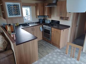 een kleine keuken met houten kasten en een fornuis bij The Highlander in Tain +7 foto's