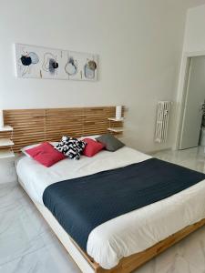 - un grand lit avec des oreillers rouges dans une chambre dans l'établissement San Paolo sweet home, à Rome