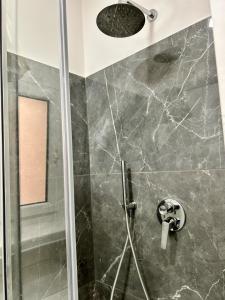 La salle de bains est pourvue d'une douche avec une porte en verre. dans l'établissement San Paolo sweet home, à Rome