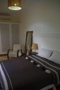 - une chambre avec un lit, deux chaises et une lampe dans l'établissement Riad rénové en 2023, idéalement situé, 5 minutes de la place Jemaa El Fna, à Marrakech