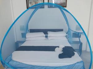 a bed in a blue tent with a teddy bear on it at Ridge Boundary View in Dambulla