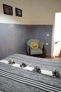 - une chambre avec un lit et une chaise avec un chapeau dans l'établissement Riad rénové en 2023, idéalement situé, 5 minutes de la place Jemaa El Fna, à Marrakech