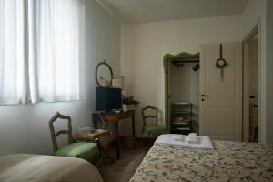 Schlafzimmer mit einem Bett, einem Tisch und einem Spiegel in der Unterkunft AGRIFOGLIO in Pantalla