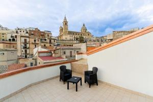 a balcony with two chairs and a view of a city at Domus Teja in Agira