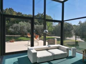 L'Orangerie - Villa with private indoor swimming pool and hammam في بورتاليجري: غرفة معيشة مع أريكة بيضاء ونوافذ كبيرة