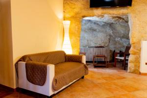 a living room with a couch and a stone wall at Domus Teja in Agira