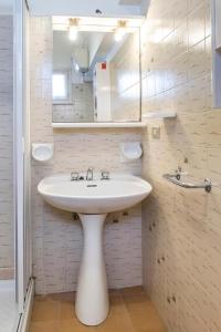 un bagno bianco con lavandino e specchio di Comodo bilocale a Marcelli - M271 a Marcelli