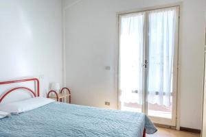 una camera da letto con un letto e una grande finestra di Comodo bilocale a Marcelli - M271 a Marcelli