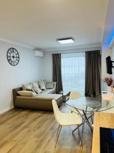 a living room with a couch and a glass table at Cozy Apartments Avanera Suceava in Suceava