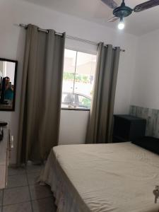 um quarto com uma cama e uma janela em Temporada Praia de Setiba em Guarapari