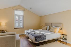 a bedroom with a large bed and a couch at Primeiro Quartel Apartments - 5 in Peso da Régua