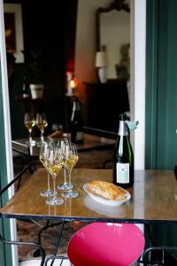 einen Tisch mit Gläsern Wein und einem Teller Brot in der Unterkunft Maison au cœur des vignes in Épernay