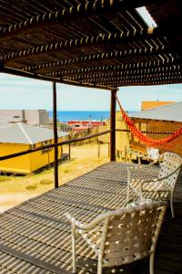 a table and two chairs on a deck with the beach at En calma in Punta Del Diablo