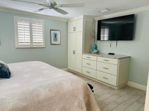- une chambre avec un lit et une télévision à écran plat dans l'établissement Island House Beach Resort V17 villa, à Siesta Key