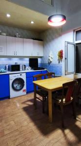 cocina con mesa de madera y armarios azules en Sea Side, en Baku