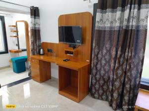 a room with a desk with a tv and a mirror at Singanama RESORT in Pachmarhī