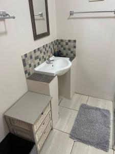 ein weißes Badezimmer mit einem Waschbecken und einem Spiegel in der Unterkunft Restful Retreat in Hilton