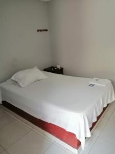 a bed in a room with a white bedvisor at Hotel La Mata in La Mata
