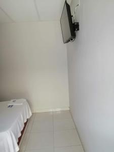 Habitación blanca con TV en la pared en Hotel La Mata 