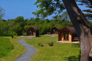 a couple of small wooden cabins in a yard at Robin- Ensuite Glamping Pod in Truro
