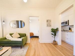een woonkamer met een groene bank en een keuken bij Highfall Hideaway Your Cozy Escapetvpetswi-fi in Rochester