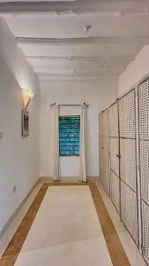 a white room with a window and a hallway with lockers at Villa Marine Park - Malindi in Malindi