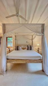 a bedroom with a bed with a canopy at Villa Marine Park - Malindi in Malindi