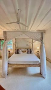 a bedroom with a canopy bed with a ceiling at Villa Marine Park - Malindi in Malindi