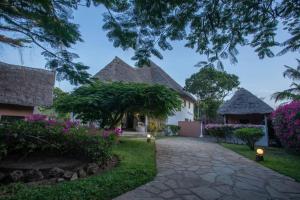 a pathway leading to a house with flowers at Villa Marine Park - Malindi in Malindi