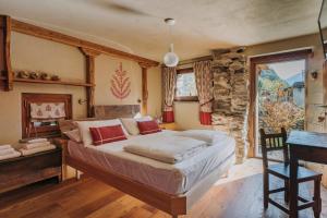 1 dormitorio con cama, escritorio y ventana en Au coeur du village Chambes d'hôtes & SPA, en Arnad