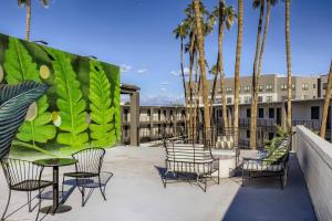 a group of chairs and tables on a patio with palm trees at Lush 2bd In Heart Of Tempe Near Beachparkdtwifi in Tempe