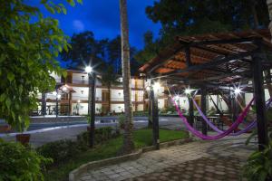 una pérgola con cuerdas púrpuras frente a un edificio en Hotel Plaza Palenque, en Palenque