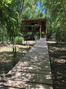 una pasarela de madera que conduce a una cabaña en el bosque en Cabaña Isla Coco en Tigre