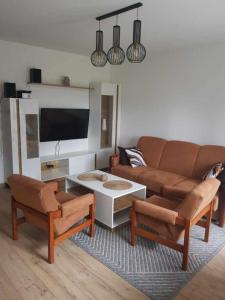 a living room with a couch and a table and chairs at Apartament Chrobry in Kętrzyn