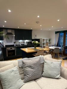 a living room with a couch and a kitchen at Little Kent End Cottage in Ashton Keynes
