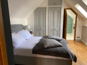 a bedroom with a bed with white sheets and pillows at Little Kent End Cottage in Ashton Keynes