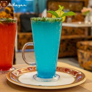 una bevanda blu in una tazza su un piatto di Hotel City View a Navi Mumbai