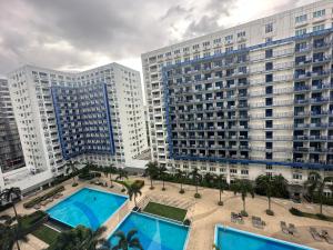 eine Luftansicht von zwei großen Gebäuden mit Palmen in der Unterkunft Staycation for you at Casa Amara near MOA in Manila