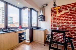 a kitchen with a red brick wall and a table at Amazing Location In The Center For 8 in Sofia